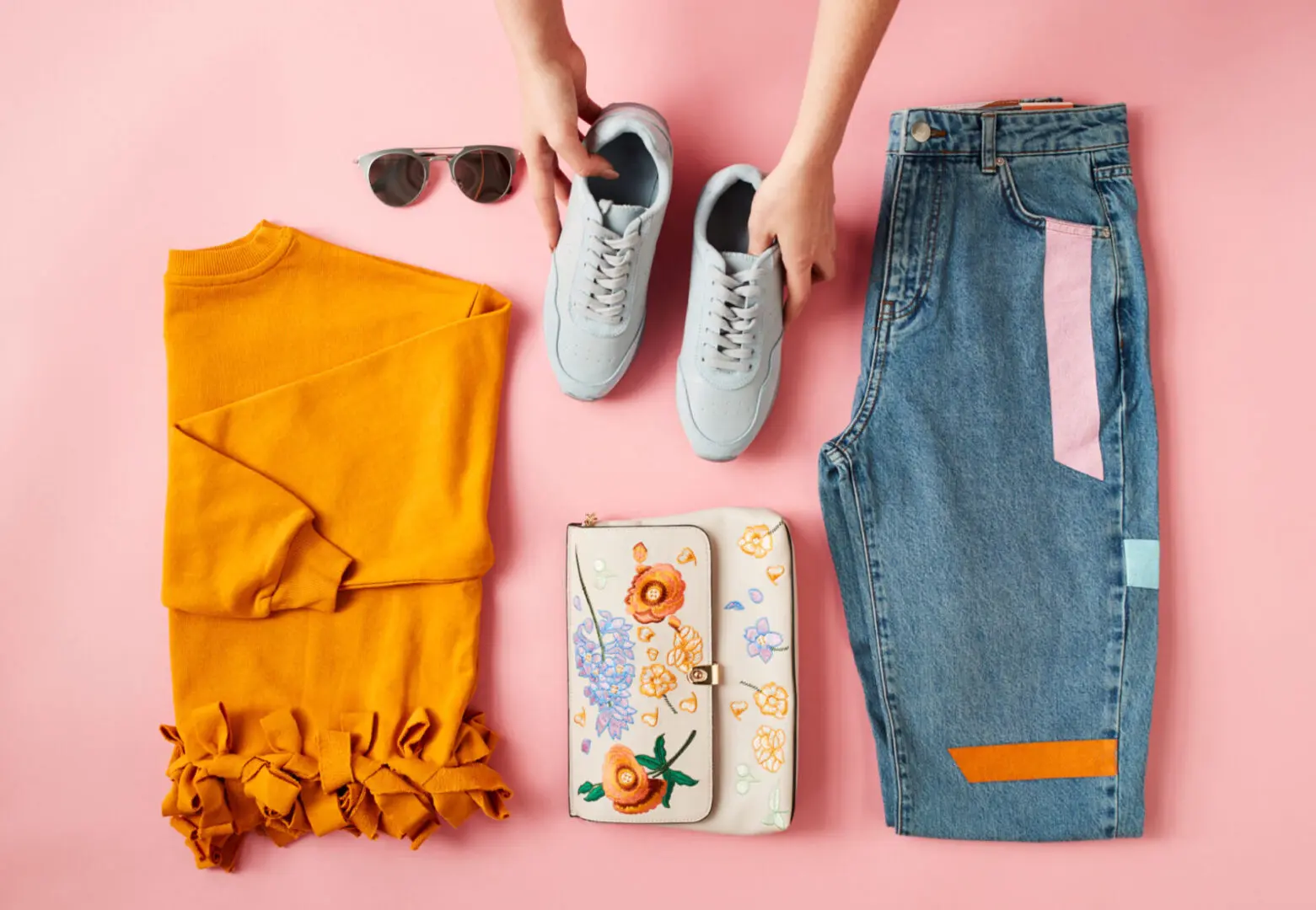 Colorful clothing and accessories on pink background.