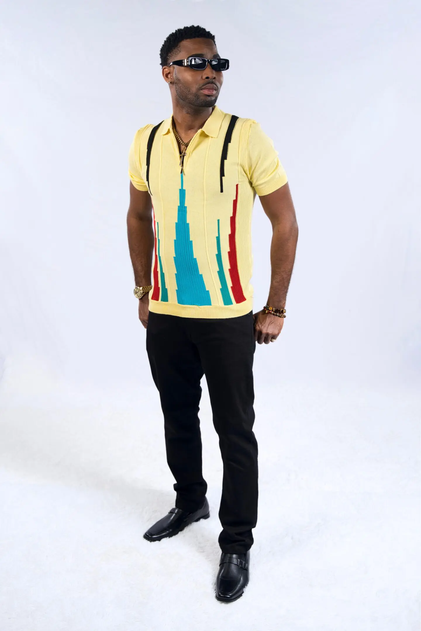 Man wearing a colorful polo shirt and black pants.