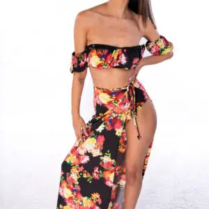 Woman wearing a floral two-piece outfit with a high slit skirt.