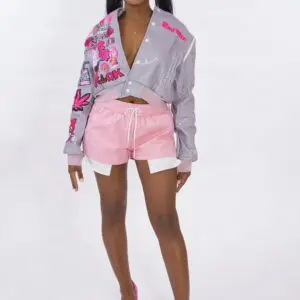 Woman wearing a floral gray jacket and pink shorts.