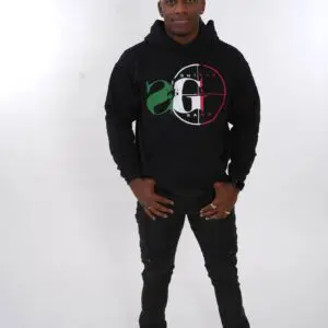 Person in a black hoodie and ripped jeans standing against a white background.