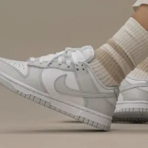 Close-up of a white Nike sneaker paired with beige socks.