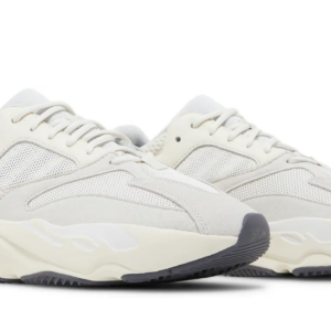 Pair of white athletic sneakers with chunky soles and subtle wave patterns.