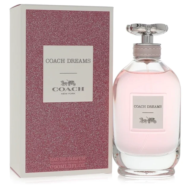 A bottle and box of Coach Dreams perfume in pink and clear glass.